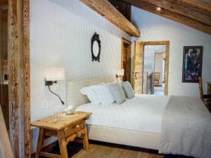 a bedroom with a white bed and a wooden table at Arlberg View Residence in St. Moritz