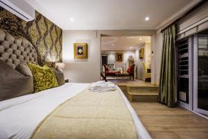 a bedroom with a large bed and a living room at 17 On Cedar Boutique Guesthouse in Durbanville +66 photos