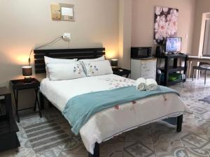 a bedroom with a large bed with two towels on it at Meerensee tranquil suite in Richards Bay