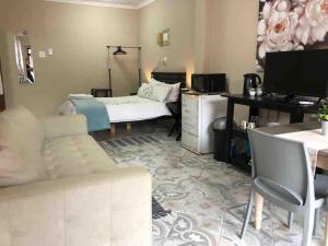 a living room with a bed and a desk at Meerensee tranquil suite in Richards Bay