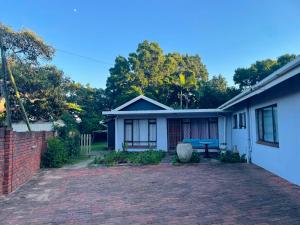 a house with a brick driveway in front of it at Meerensee tranquil suite in Richards Bay