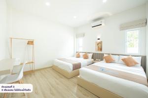 a bedroom with two beds and a desk and a chair at Seahorse poolvilla sattahip SP2 in Ban Nong Sa +10 photos