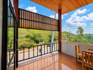 a room with a balcony with a large window at Samanta By The Hill in Ko Larn