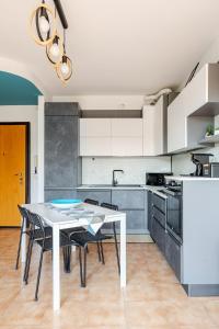 a kitchen with a white table and black chairs at Soffio di Luce in Calderara di Reno