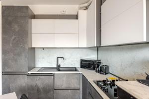 a kitchen with white cabinets and a sink at Soffio di Luce in Calderara di Reno