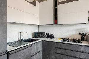 a kitchen with white cabinets and a sink at Soffio di Luce in Calderara di Reno