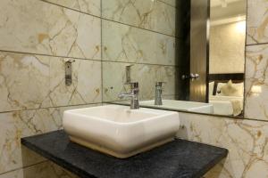 a bathroom with a white sink and a mirror at Hotel Cloud Suites Delhi Airport in New Delhi +53 photos