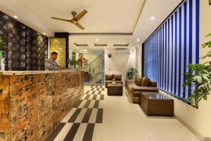 a lobby of a hotel with a man standing at a counter at Hotel Cloud Suites Delhi Airport in New Delhi