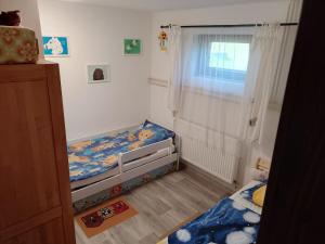 a small bedroom with a bed and a window at Ubytování u J & J in Lauterwasser