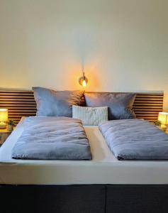 a bed with two pillows on it in a room at Gasthof Schausten in Kreuztal