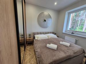 a bedroom with a bed with two towels on it at Apartamenty u Justyny - Ametyst in Borne Sulinowo