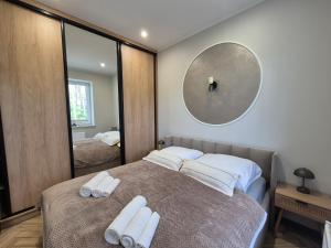 a bedroom with a bed with two towels on it at Apartamenty u Justyny - Ametyst in Borne Sulinowo