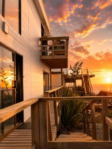 Ein Haus mit Terrasse, im Hintergrund ein Sonnenuntergang in der Unterkunft Del sol 3 in La Boca