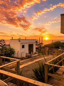 ein Haus mit dem Sonnenuntergang im Hintergrund in der Unterkunft Del sol 3 in La Boca + 3 Fotos