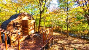 a rv sitting on a deck in the woods at rinne 2nd living Sauna Villa Nasu in Nasu