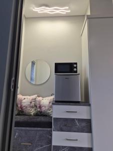 a room with a microwave on a counter and a mirror at 8 Guildford in George
