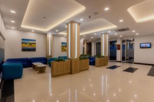 a lobby of a hospital with blue furniture and pillars at Azana Oasis Hotel Aceh in Luengbata