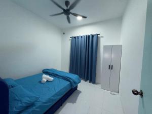 a bedroom with a bed with a teddy bear on it at AiNi's Homestay in Sipitang
