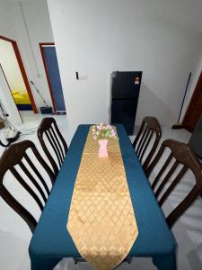 a blue table with chairs and a vase of flowers on it at AiNi's Homestay in Sipitang