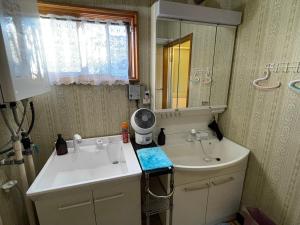 a bathroom with a sink and a mirror at EZO HOUSE in Kawayu