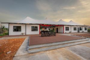 a large white tent with tables and chairs on a deck at Spacious 5BR Canopy Home with Farm in Kepala Batas