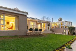 a house with a lawn in front of it at 17 On Cedar Boutique Guesthouse in Durbanville