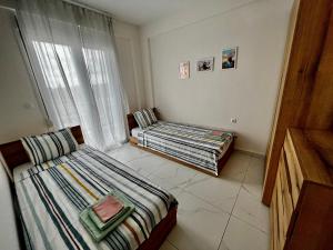 a room with two beds and a window at BELA Apartments Kariani Near Ofrinio in Karianí