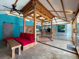 a living room with a red couch and a table at Villa Harimau-Original Joglo style 3B with pool in Gili Trawangan