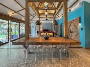 a dining room with a large wooden table and chairs at Villa Harimau-Original Joglo style 3B with pool in Gili Trawangan