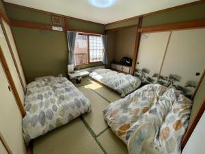 a room with two beds and a window at EZO HOUSE in Kawayu