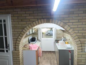 a kitchen with an archway in a brick wall at Sumski raj Gornje podunavlje in Sombor