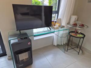 a flat screen tv sitting on top of a glass table at 8 Guildford in George