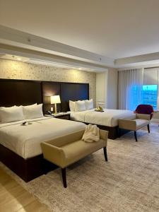 a large hotel room with two beds and a couch at Paradise Grand Hotel Delhi igi Airport in Etāwah