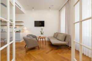 a living room with two chairs and a table at Apartamenty Bracka 6 in Krakow