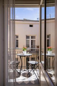 a balcony with two tables and chairs on a balcony at Apartamenty Bracka 6 in Krakow