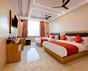 a hotel room with two beds and a television at Paradise Grand Hotel Delhi igi Airport in Etāwah +29 photos