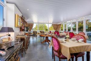 a dining room with tables and chairs and windows at 17 On Cedar Boutique Guesthouse in Durbanville