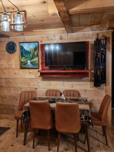 ein Esszimmer mit einem Tisch und einem Flachbildfernseher in der Unterkunft Sabauri in Khulo
