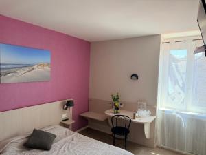 a bedroom with a purple wall and a bed and a desk at Au bon saint Nicolas in Hillion +3 photos