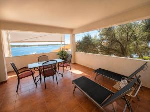 a room with a table and chairs and a large window at Rab Pandelo Apartmani in Rab