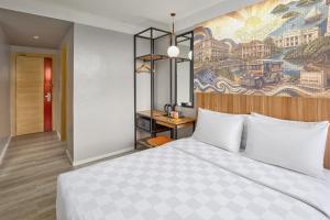 a hotel room with a bed and a painting on the wall at Go Hotels Iloilo in Iloilo City +21 photos