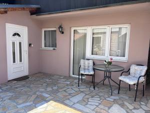 a patio with a table and chairs and windows at Apartman MiNa in Mataruška Banja