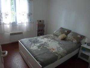 a small bedroom with a bed in a room at Maison huit places Piscine tennis Lacanau plage in Lacanau +6 photos