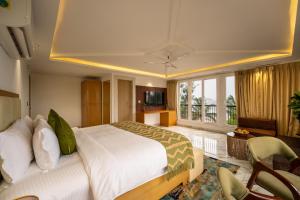 a bedroom with a large bed and a living room at White Wharf Beach Resort Morjim Goa in Morjim