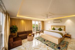 a hotel room with a bed and a couch at White Wharf Beach Resort Morjim Goa in Morjim +101 photos