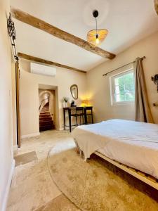 a bedroom with a large bed and a staircase at Mas du Rocan in Aubignan