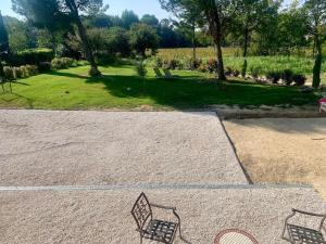 a park with two benches sitting on the ground at Mas du Rocan in Aubignan +5 photos