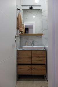 a bathroom with a sink and a mirror at Apartmani Savić expres Laktasi in Laktaši +16 photos