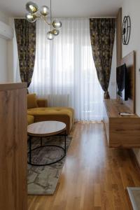 a living room with a couch and a table at Apartmani Savić expres Laktasi in Laktaši