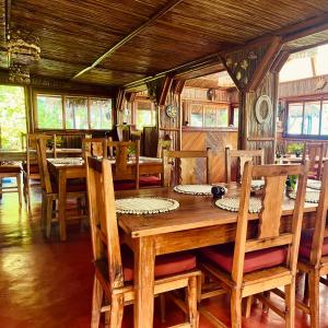 a dining room with a wooden table and chairs at Mahanoro Hotel & Restaurant in Sainte Marie +26 photos